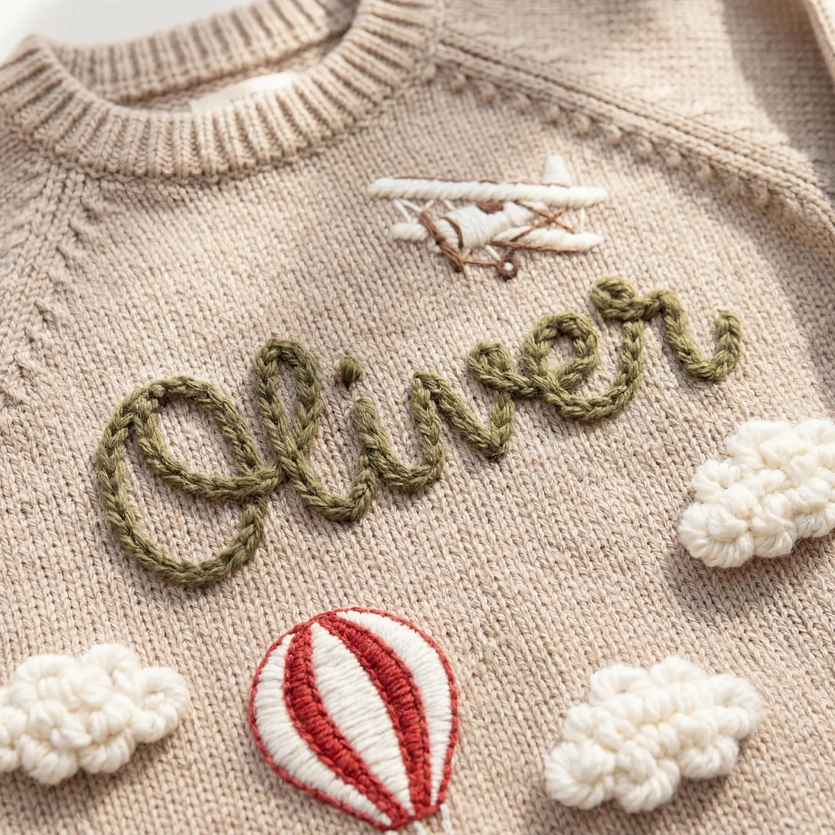 Close-up of raised embroidery spelling Oliver on a knit sweater
